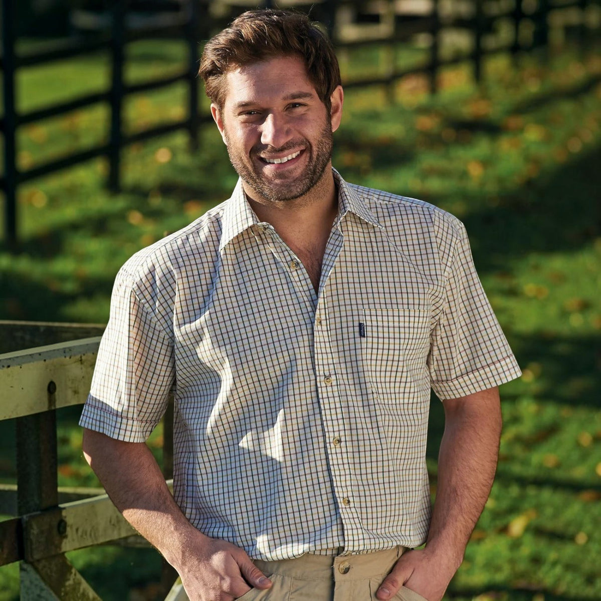 BATA LTD Champion men's short-sleeved tattersall check shirt in beige and green worn by a smiling man outdoors.