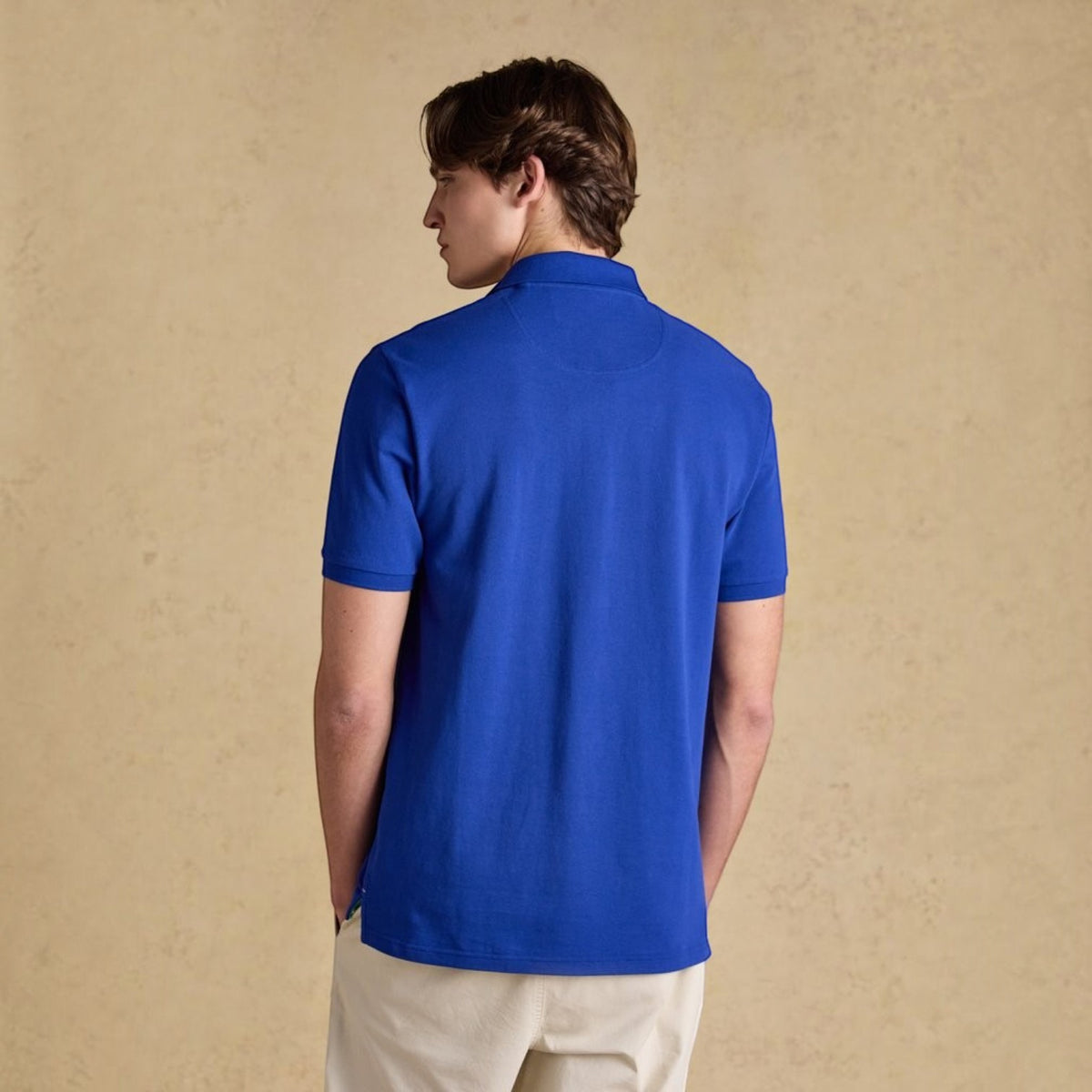 BATA LTD Joules Woody blue cotton pique polo shirt worn by a man, back view showing short sleeves and collar