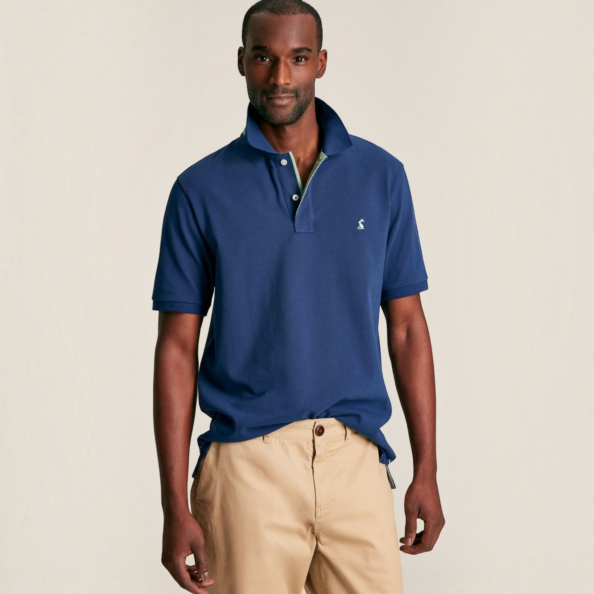 BATA LTD Joules Woody blue cotton pique polo shirt with embroidered hare logo and button placket on a male model