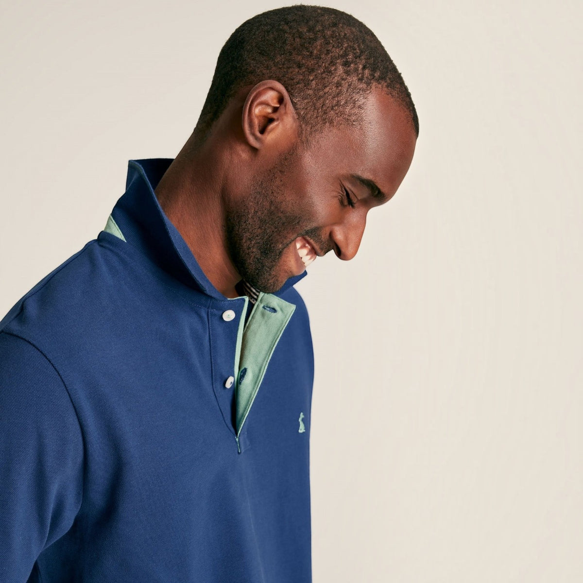 BATA LTD Joules Woody blue cotton pique polo shirt with contrasting green undercollar and embroidered chest hare