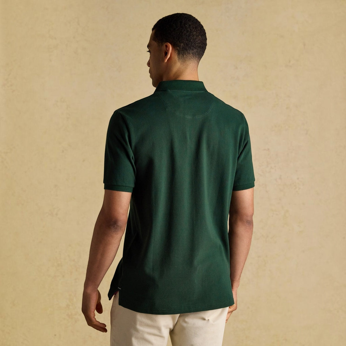 BATA LTD Joules Woody dark green cotton pique polo shirt worn by a man, back view showing short sleeves