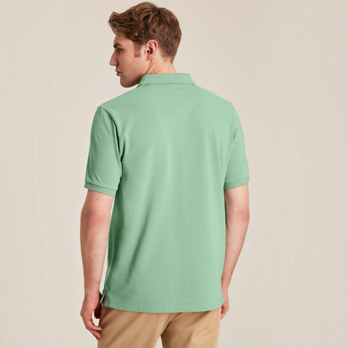 BATA LTD Joules Woody polo shirt in light green cotton pique, back view on a model wearing tan trousers.