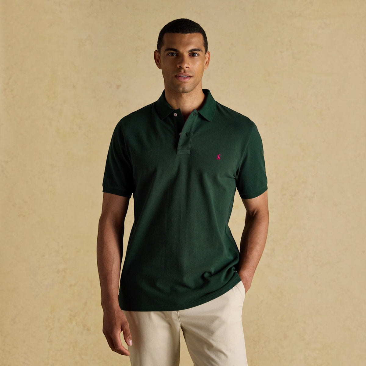 BATA LTD Joules Woody dark green cotton pique polo shirt with embroidered hare logo worn by a male model