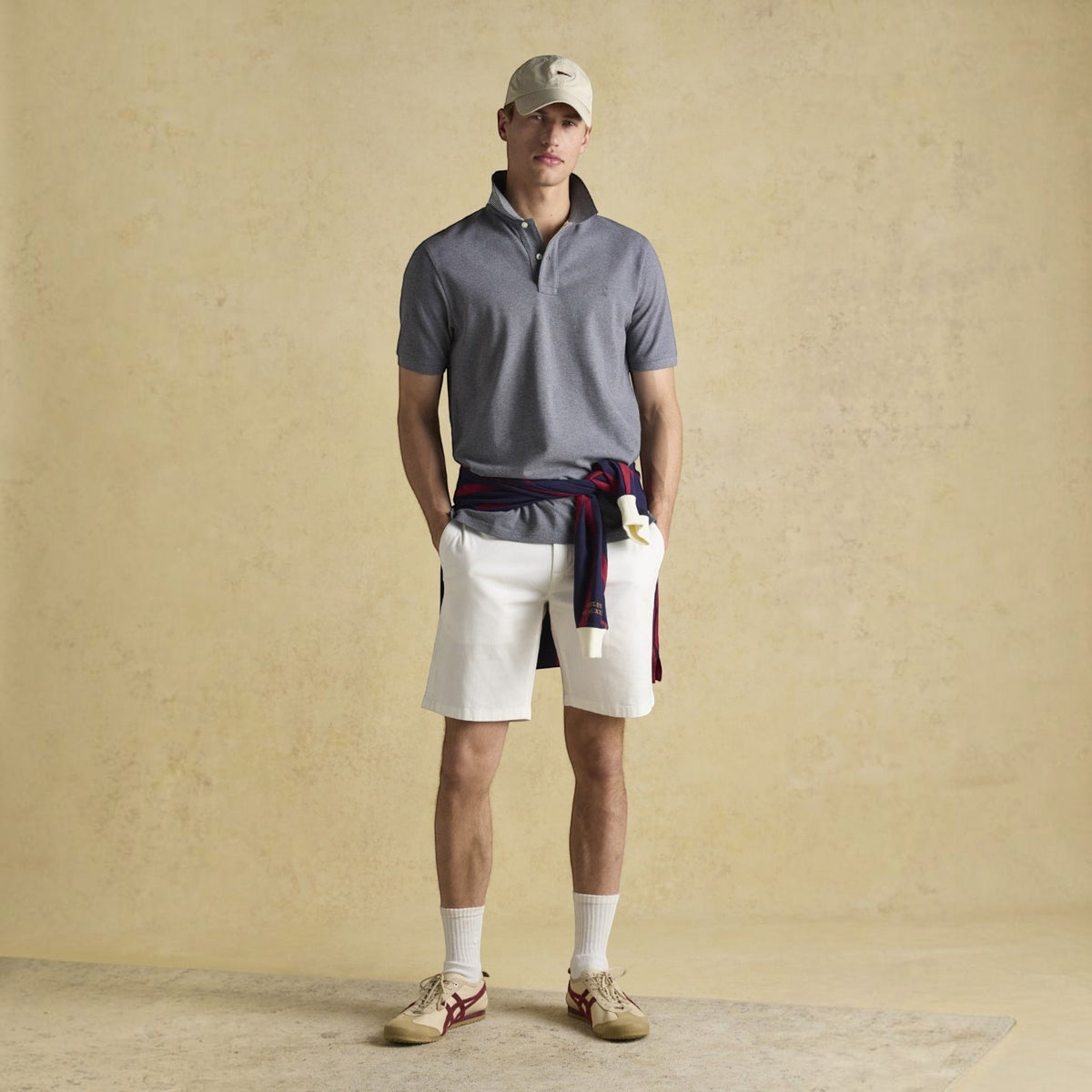 BATA LTD Joules Woody grey cotton pique polo shirt with embroidered hare, worn by a man with white shorts and cap